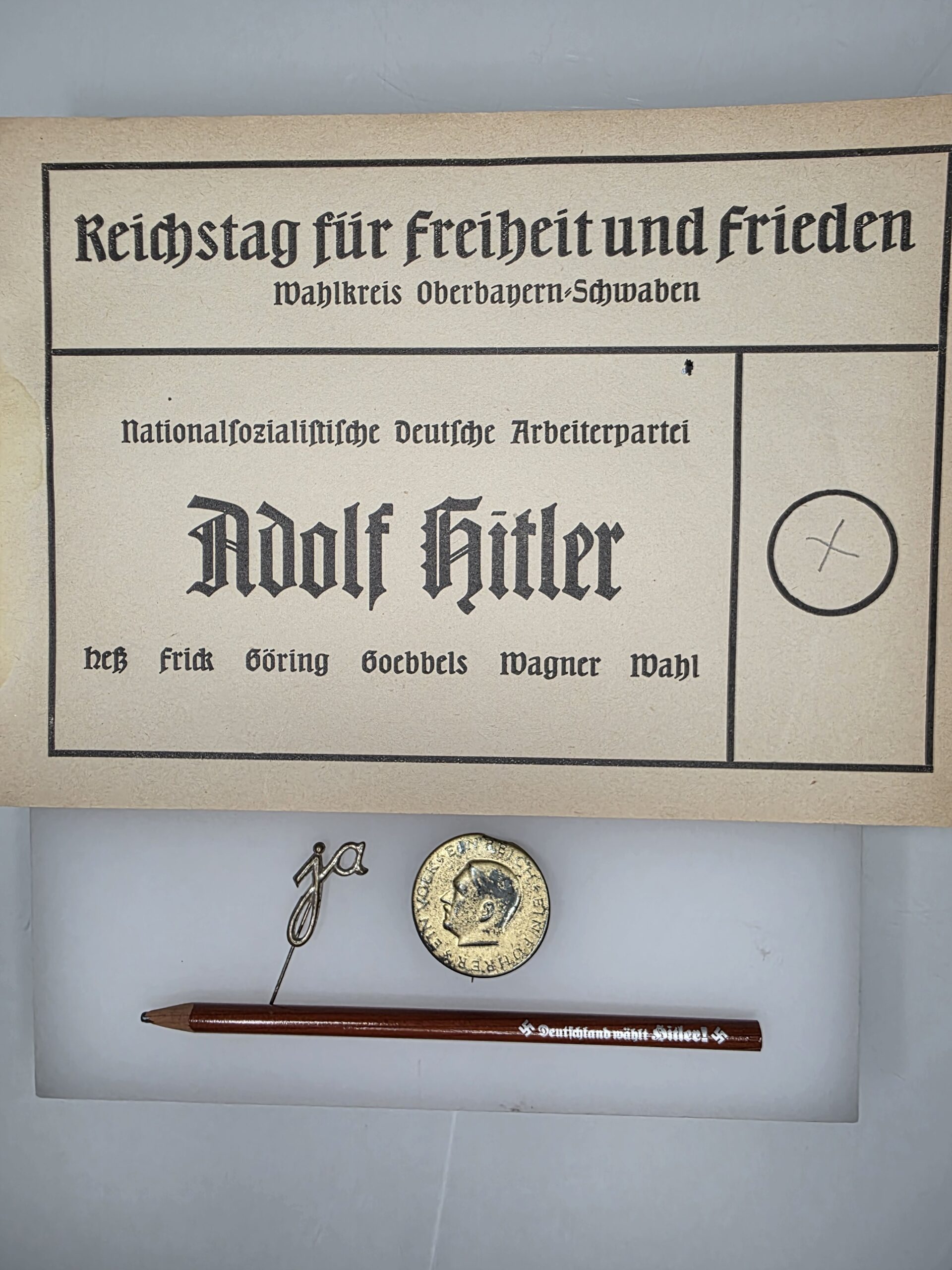 Original Hitler propaganda pencil and two Third Reich election badges Original Hitler propaganda pencil and two Third Reich election badges