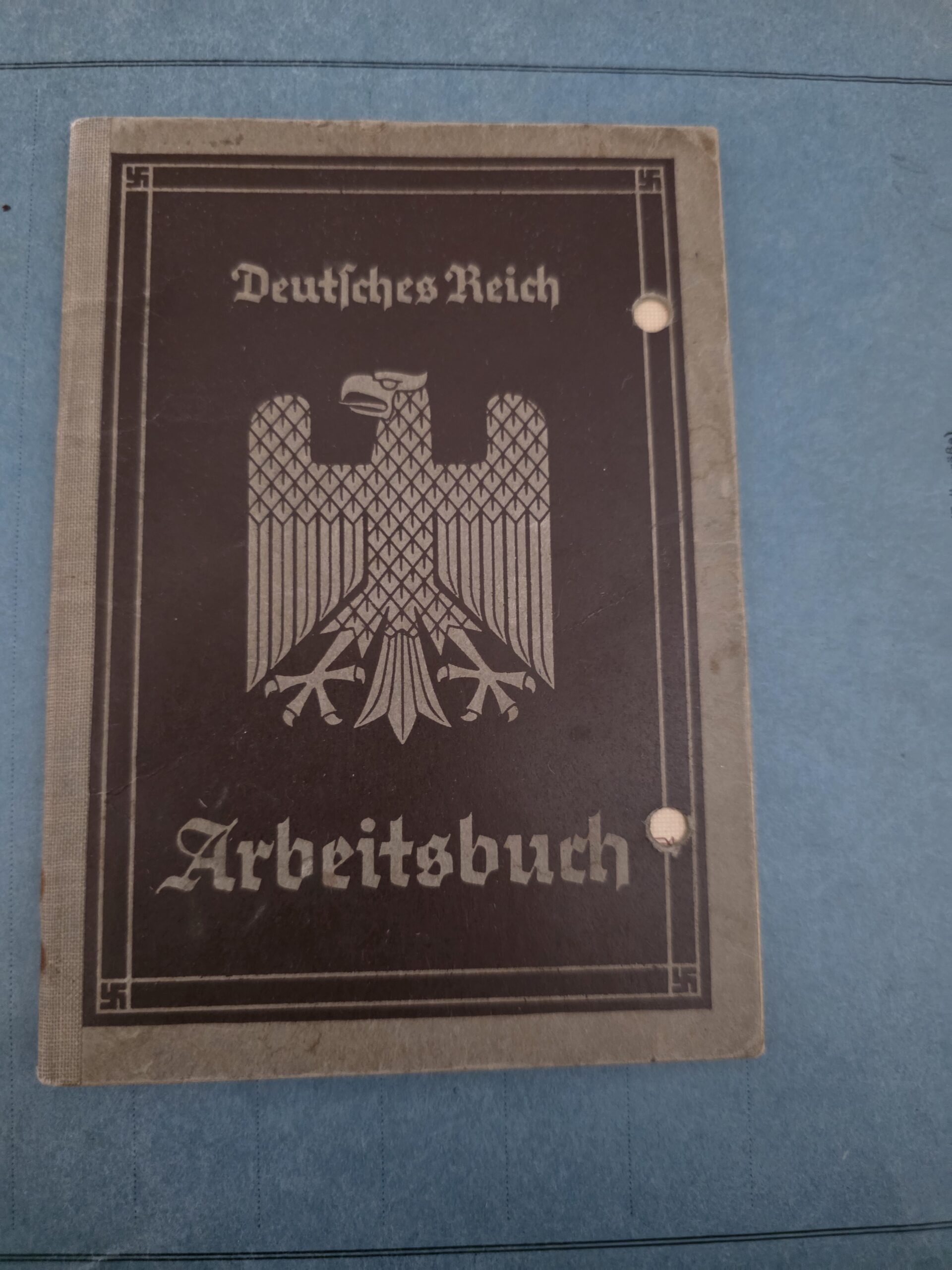 First-Pattern German Arbeitsbuch – Wilhelm Hils OFront view showing the characteristic early eagle, Fraktur lettering, four small corner swastikas and two period filing holes.Front view showing the characteristic early eagle, Fraktur lettering, four small corner swastikas and two period filing holes.riginal first-pattern German Arbeitsbuch belonging to Wilhelm Hils