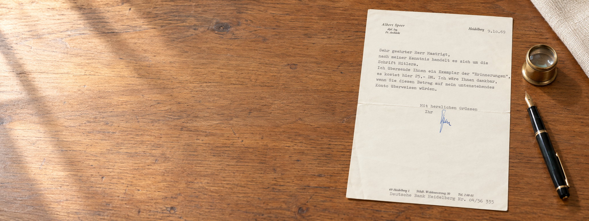 Historical autographs: signed letter beside a fountain pen on a wooden desk